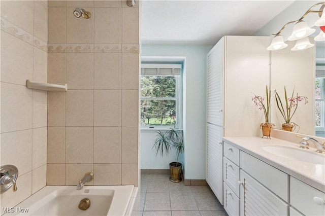 bathroom with tile patterned floors, baseboards, vanity, and a bath
