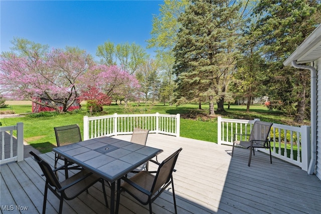deck featuring a lawn and outdoor dining space