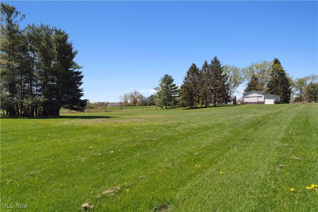 view of yard featuring a detached garage and a rural view