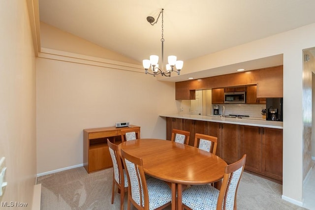 dining space featuring baseboards, lofted ceiling, a notable chandelier, and light carpet