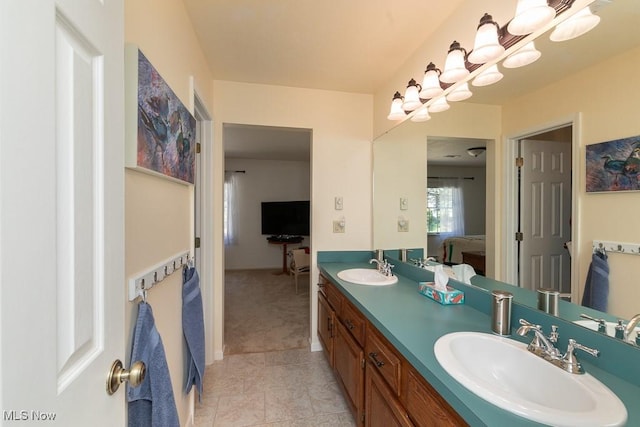 ensuite bathroom featuring a sink, tile patterned floors, double vanity, and connected bathroom