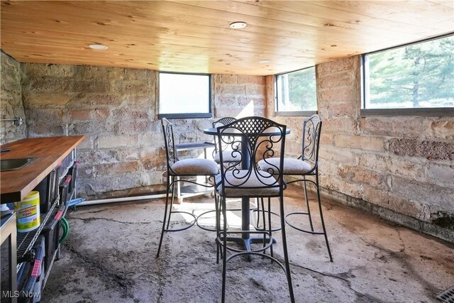 dining room with concrete floors and wood ceiling