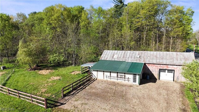 exterior space featuring fence, an outbuilding, an exterior structure, and driveway