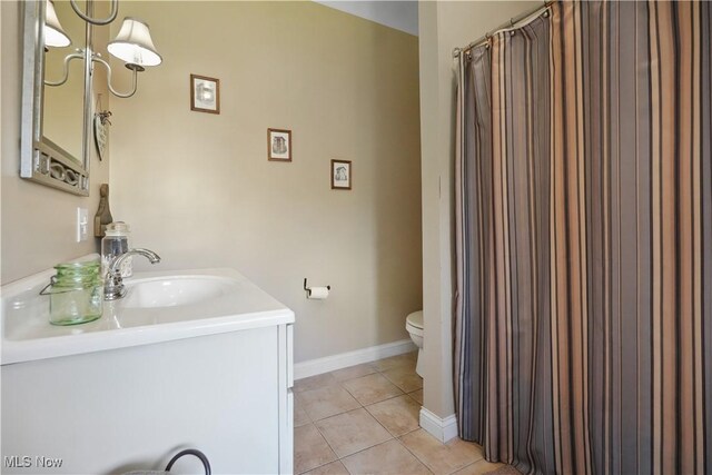 full bathroom with tile patterned flooring, vanity, toilet, baseboards, and a shower with curtain