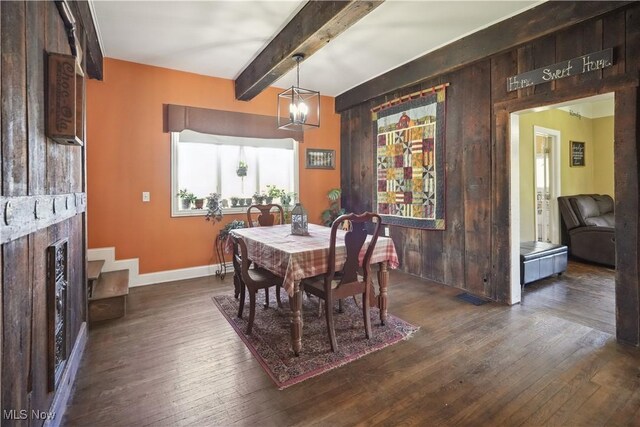 dining area featuring baseboards, a fireplace, beam ceiling, and dark wood-type flooring