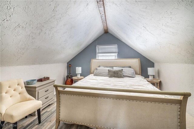 bedroom featuring vaulted ceiling and light wood-style flooring