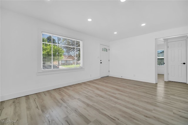 unfurnished living room with baseboards, light wood-type flooring, and recessed lighting