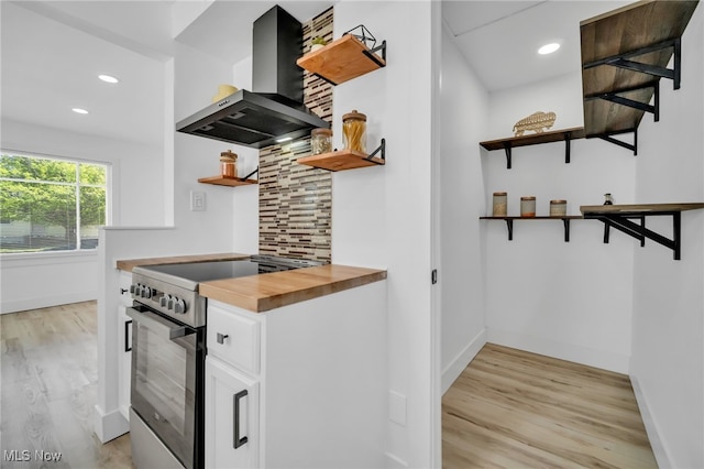 4392 E 144th St, Cleveland, OH 44128 - kitchen featuring open shelves, wall chimney range hood, butcher block countertops, stainless steel electric range oven, and light wood-type flooring