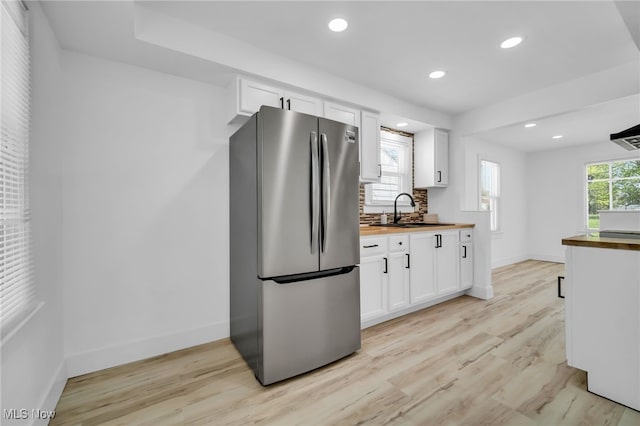 4392 E 144th St, Cleveland, OH 44128 - kitchen with freestanding refrigerator, wooden counters, a sink, baseboards, and white cabinets