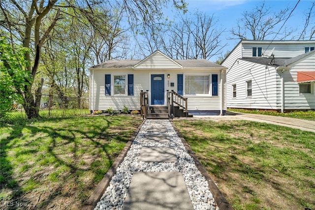 bungalow-style house featuring fence and a front lawn