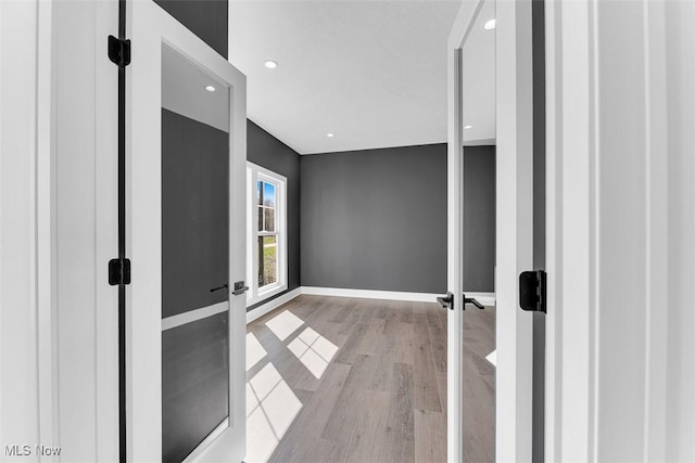 hall featuring baseboards, recessed lighting, french doors, and wood finished floors