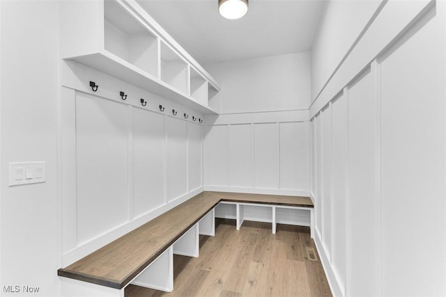 mudroom featuring a decorative wall and wood finished floors