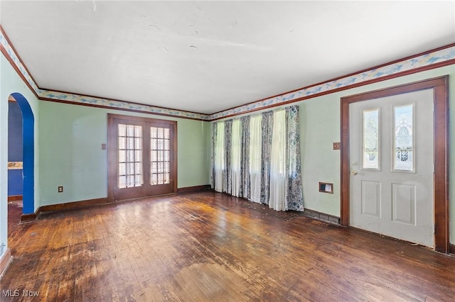 foyer entrance featuring wood-type flooring, arched walkways, french doors, baseboards, and a healthy amount of sunlight