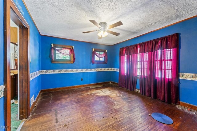 unfurnished room with a ceiling fan, a textured ceiling, baseboards, and hardwood / wood-style floors