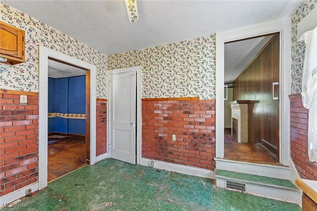 interior space with visible vents, carpet flooring, a fireplace, and wallpapered walls