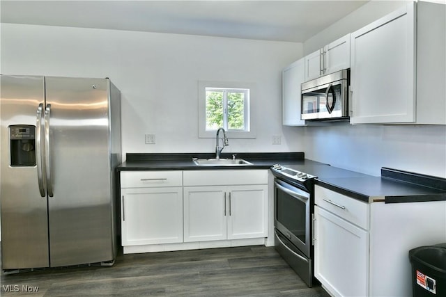 1553 Parkman Rd NW, Warren, OH 44485 - kitchen with a sink, appliances with stainless steel finishes, white cabinets, and dark countertops