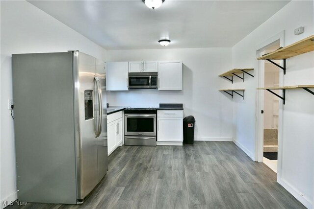 1553 Parkman Rd NW, Warren, OH 44485 - kitchen featuring baseboards, white cabinetry, dark countertops, and stainless steel appliances