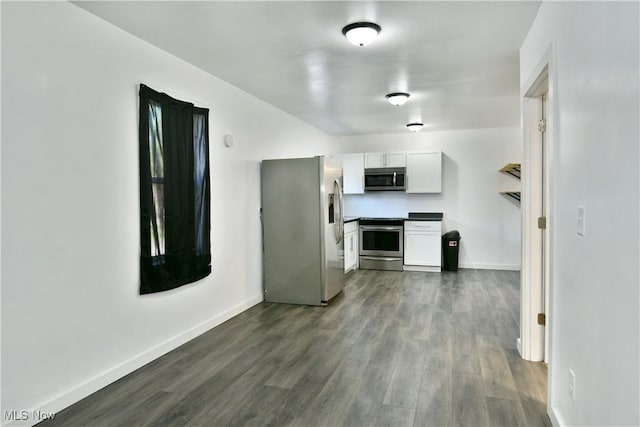 1553 Parkman Rd NW, Warren, OH 44485 - kitchen with dark wood-style flooring, stainless steel appliances, baseboards, and white cabinetry