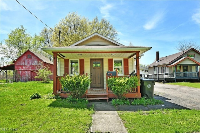 1553 Parkman Rd NW, Warren, OH 44485 - view of front of property featuring a porch, a barn, an outdoor structure, and a front yard