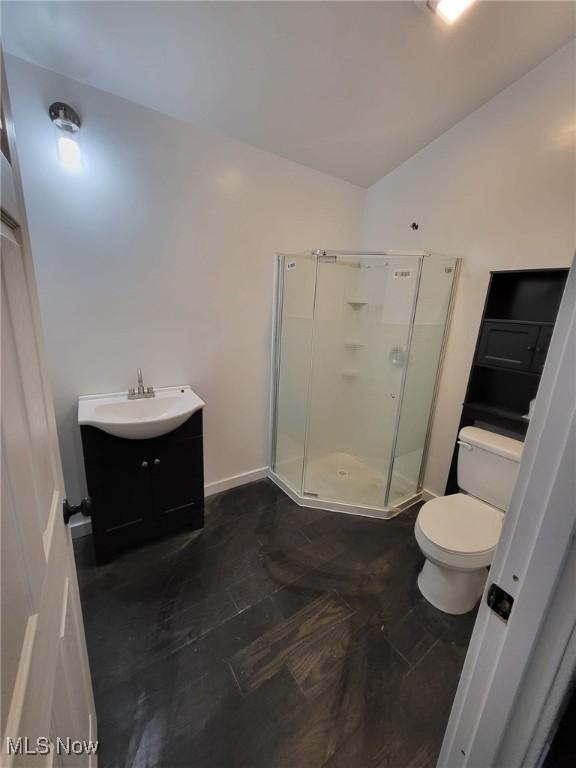 1553 Parkman Rd NW, Warren, OH 44485 - bathroom featuring vanity, wood finished floors, toilet, a shower stall, and vaulted ceiling