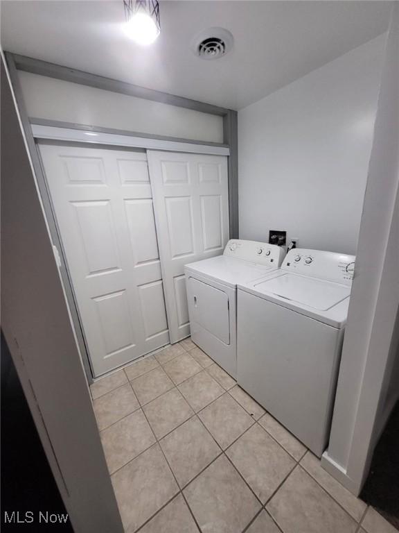 1553 Parkman Rd NW, Warren, OH 44485 - laundry room featuring separate washer and dryer, laundry area, light tile patterned flooring, and visible vents