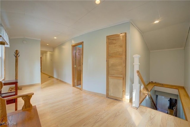 hall with crown molding, wood finished floors, baseboards, recessed lighting, and an upstairs landing