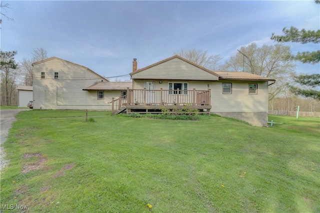back of property featuring a wooden deck, a chimney, and a yard