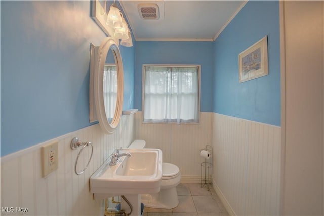 bathroom featuring visible vents, tile patterned flooring, a wainscoted wall, toilet, and ornamental molding