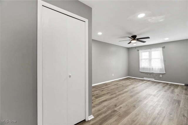 unfurnished bedroom with recessed lighting, baseboards, wood finished floors, and a closet