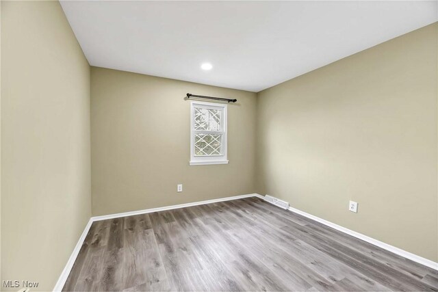 empty room featuring recessed lighting, baseboards, visible vents, and wood finished floors