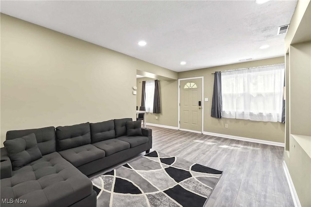 living room with baseboards, recessed lighting, wood finished floors, and visible vents