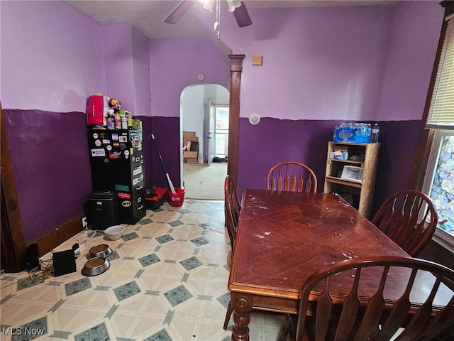 dining space with arched walkways, a ceiling fan, and a healthy amount of sunlight