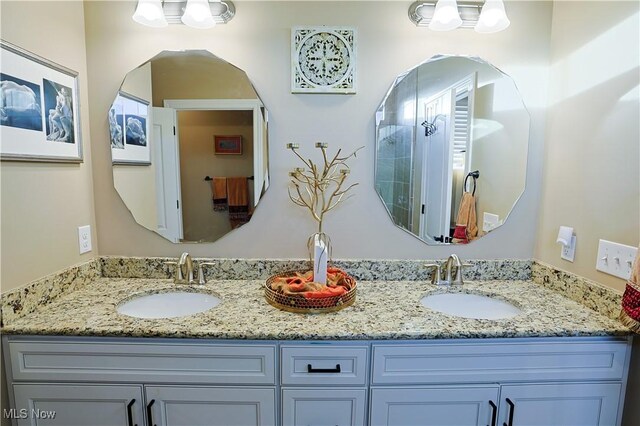 full bathroom with double vanity and a sink