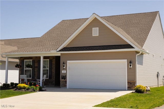 601 Cedar Crest Dr, Elyria, OH 44035 - craftsman inspired home with a porch, stone siding, driveway, an attached garage, and a shingled roof
