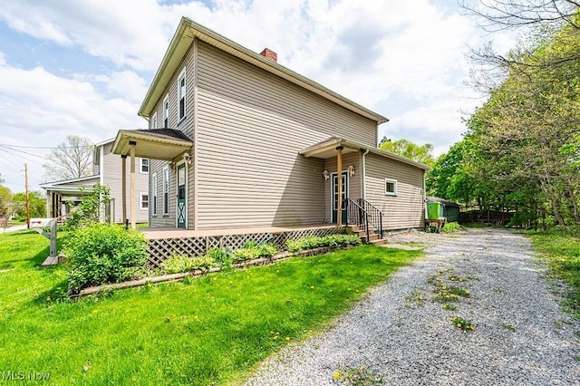 exterior space featuring a yard, driveway, and a chimney