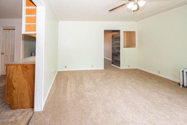 carpeted empty room featuring baseboards, a ceiling fan, and ornamental molding