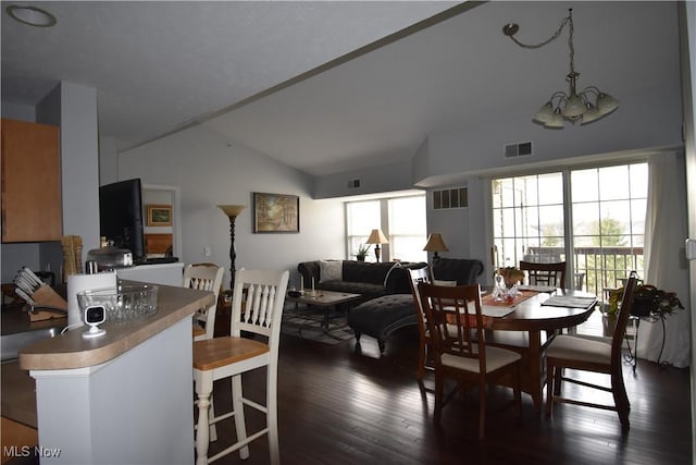 dining area with high vaulted ceiling, visible vents, and an inviting chandelier