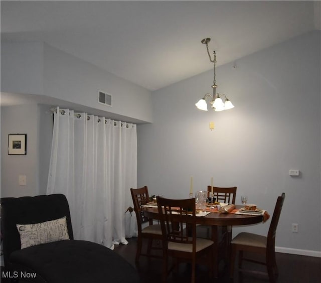 dining room with an inviting chandelier, baseboards, dark wood-type flooring, and visible vents