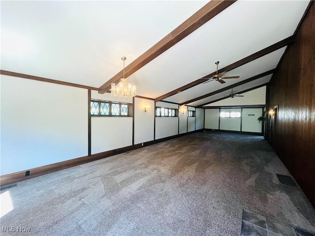empty room featuring visible vents, wood walls, beam ceiling, ceiling fan with notable chandelier, and dark colored carpet