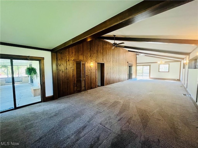 interior space featuring wood walls, vaulted ceiling with beams, carpet, and ceiling fan with notable chandelier