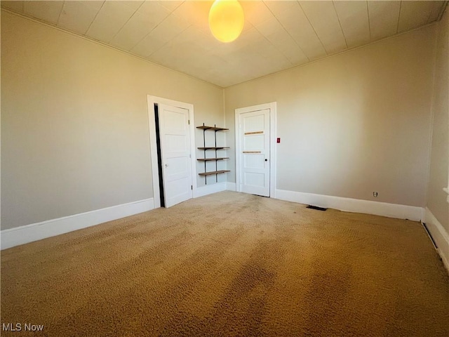 spare room with baseboards, carpet, and visible vents
