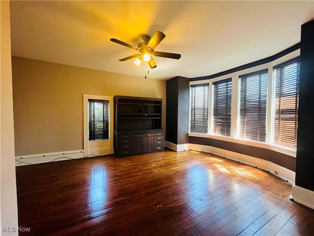 unfurnished room featuring wood-type flooring, baseboards, ceiling fan, and a wealth of natural light