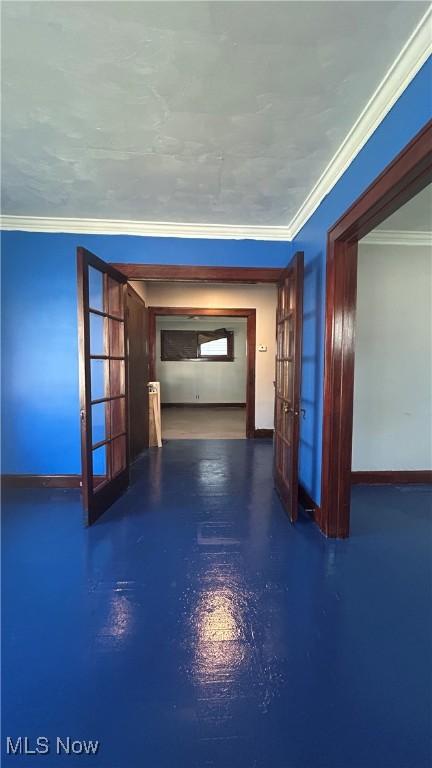 hallway featuring french doors, ornamental molding, and baseboards
