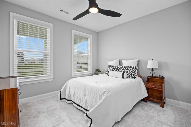 carpeted bedroom featuring baseboards, ceiling fan, and visible vents