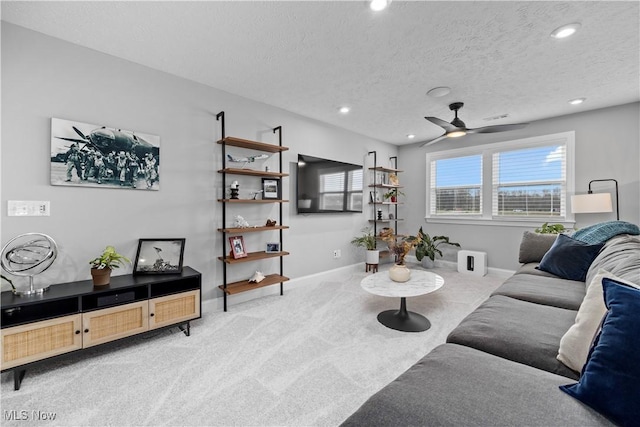 carpeted living area with baseboards, ceiling fan, recessed lighting, and a textured ceiling
