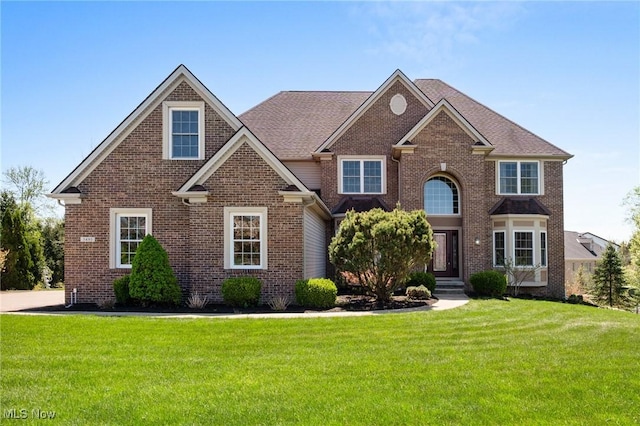 view of front of property with brick siding and a front lawn