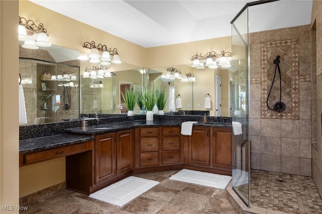 full bathroom featuring double vanity, a sink, and a stall shower