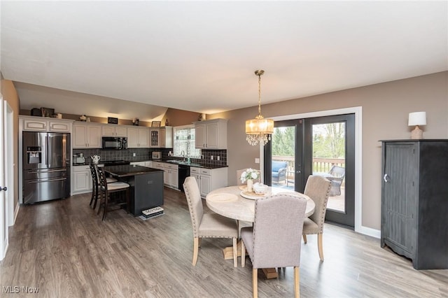 dining area with an inviting chandelier, plenty of natural light, and light wood-style flooring