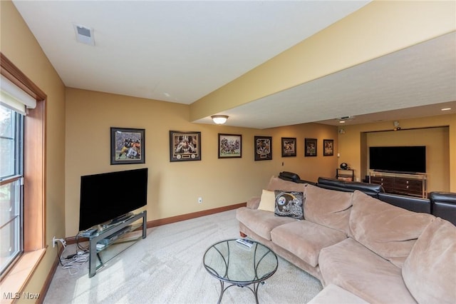 living area featuring baseboards, visible vents, and carpet