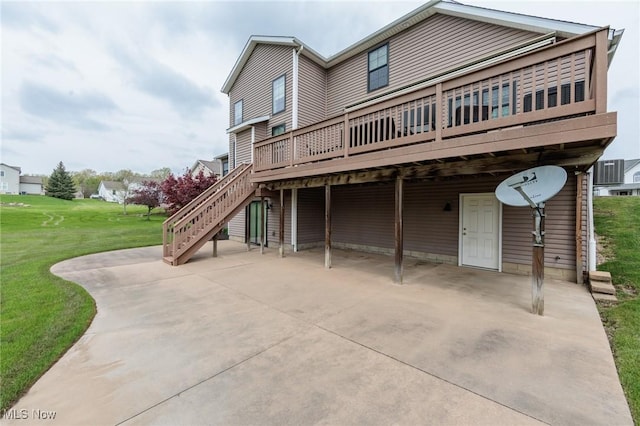 rear view of house with a lawn, a patio, stairway, and a wooden deck
